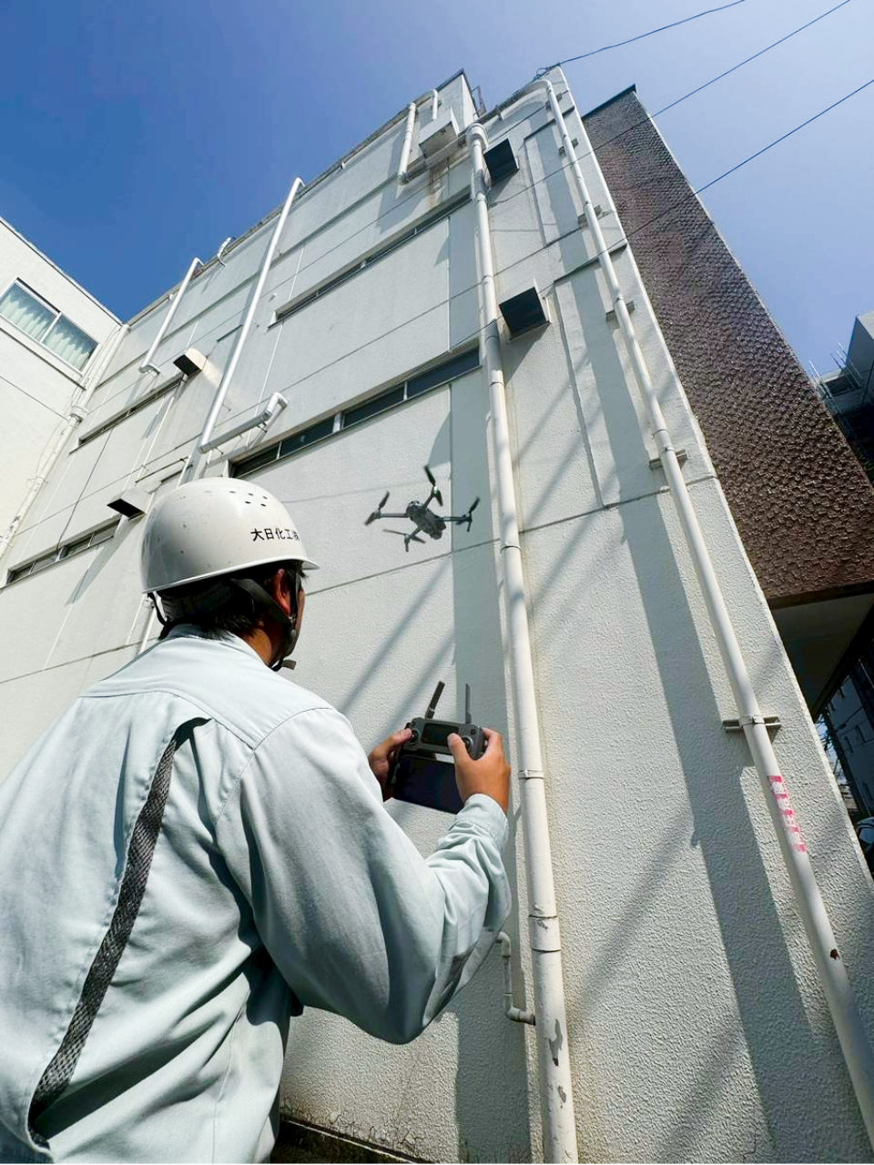 建物の上部をドローンで点検している様子